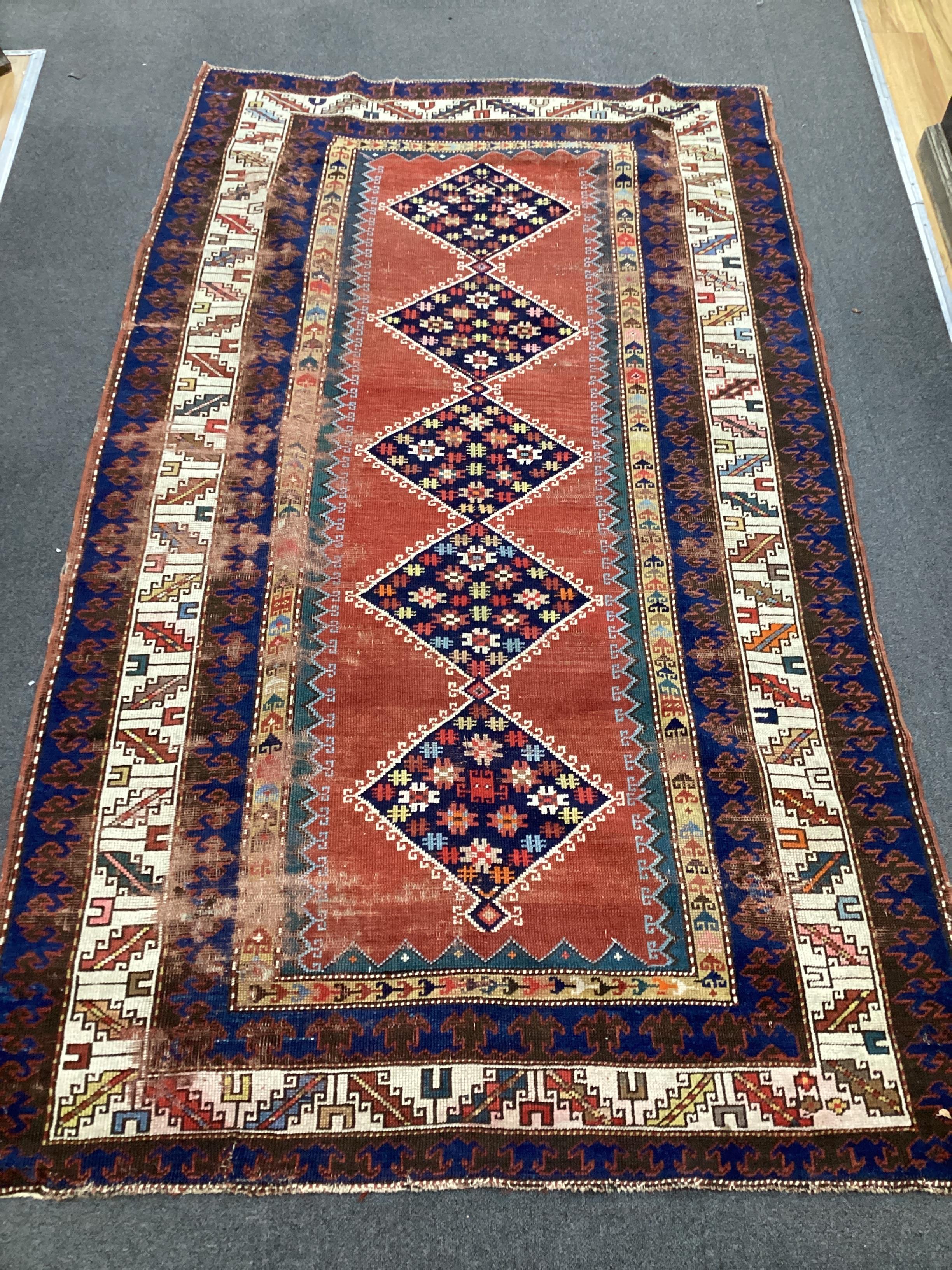 An antique Anatolian brick red ground rug, 244 x 140cm